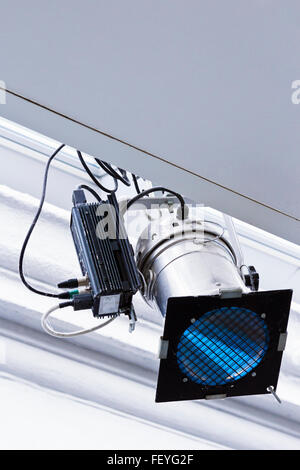 Single spotlight suspended from white ceiling Stock Photo