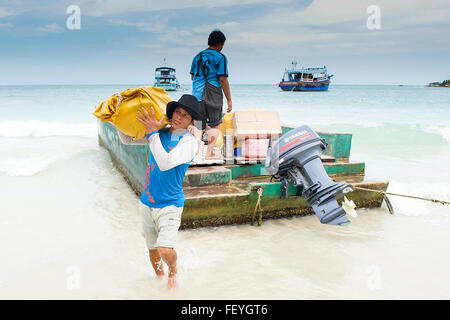 Locals unload the suitcases of tourists and supplies on the Island of Ko Samet, Gulf of Thailand, Thailand, South East Asia.