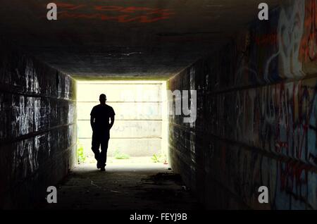 Silhouette Man Walking In Dark Tunnel