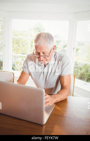 Focused senior man using laptop Stock Photo