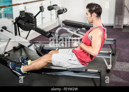 Muscular man on rowing machine Stock Photo