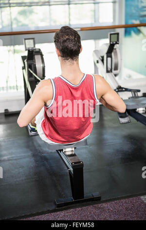 Muscular man on rowing machine Stock Photo