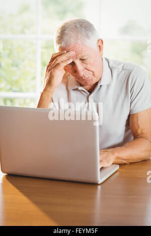 Worried senior man using laptop Stock Photo