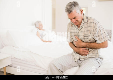 Suffering senior man holding his belly Stock Photo