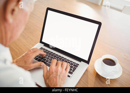 Focused elderly man typing on laptop Stock Photo