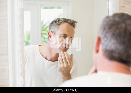 Handsome man looking at himself in the mirror Stock Photo