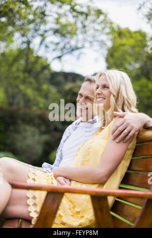 Happy couple sitting on a bench Stock Photo