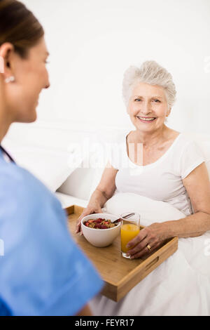 Nurse taking care of suffering senior patient Stock Photo