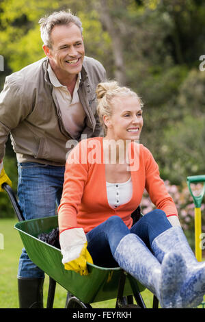 Husband pushing wife in a wheelbarrow Stock Photo