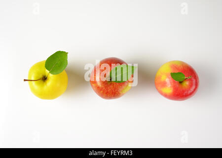 three ripe apples in a row on white background Stock Photo