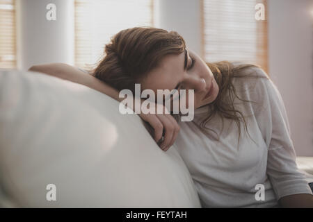 Tired woman falling asleep on the couch Stock Photo