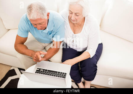 Smiling senior couple using laptop Stock Photo