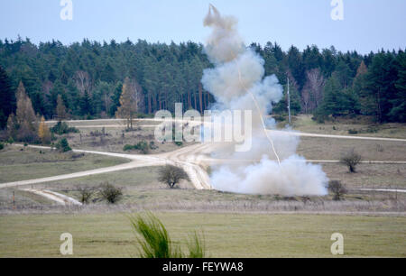 A rocket propels a line of C-4 explosive charges as soldiers from the 10th Engineer Battalion, 1st Armored Brigade Combat Team, 3rd Infantry Division fire a Mine Clearing Line Charge to breach an obstacle at Grafenwoehr Training Area, Germany, Nov. 19. The breach was part of a combined arms live-fire exercise that integrated a combined arms lane breach, dismount maneuvers, synchronized close-air support, artillery, mortars, and reconnaissance assets during the exercise. Stock Photo