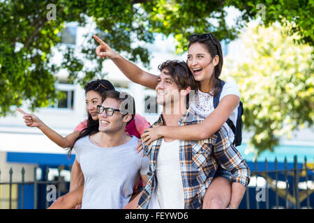 Hip men giving piggy back to their girlfriends Stock Photo