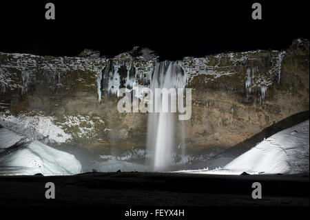 Seljalandsfoss Waterfall on the Golden Circle route lit up at night during winter in Iceland Stock Photo