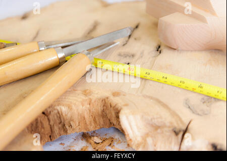 Various chisels and a steel tape measure on a piece of wood with copy space. Stock Photo