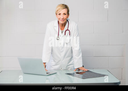 woman doctor standing behind desk Stock Photo