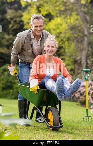 Husband pushing wife in a wheelbarrow Stock Photo