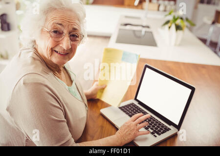 Elderly woman typing on laptop Stock Photo