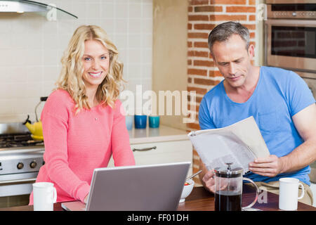 Happy couple using laptop and having breakfast Stock Photo