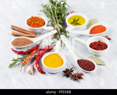 Herbs, condiments and spices on wooden background