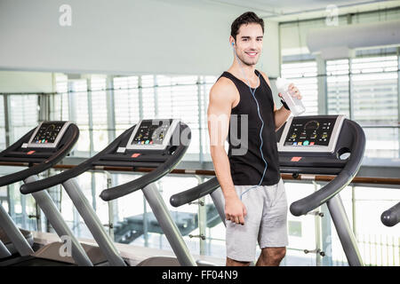 handsome man on treadmill drinking water Stock Photo
