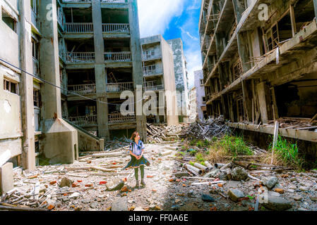 'The Student of Gunkanjima' depicts an abandoned scene on Gunkanjima, also known as Hashima Island, in Japan. The island was once a coal mining facility, now a ruin and popular spot for urban exploration. Stock Photo