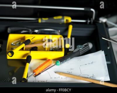 Screwdrivers and pencil above the hand drawn scheme, closeup shot with focus in the foreground Stock Photo