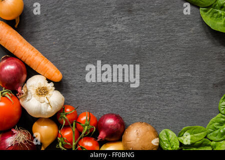 Stay fit and eat vegan. New year new resolutions. Diet with low carb food. Healthy food framing a dark slate plate Stock Photo