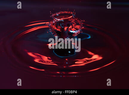 A drop of water colliding with a column of water from a previous drop, and a third drop hitting them both Stock Photo