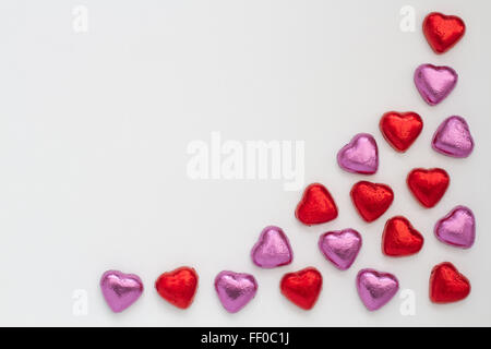Chocolate shaped hearts arranged in a pattern on an isolated white background with copy space. Stock Photo