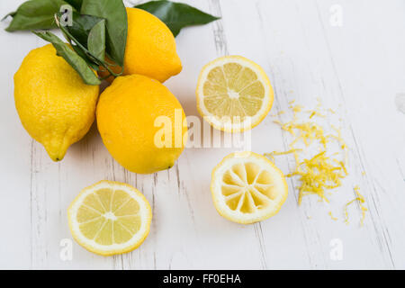 Lemons, slices and zest on a white table Stock Photo