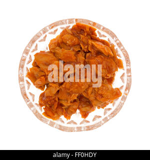 Top view of a small glass bowl of spicy flavored pink salmon isolated on a white background. Stock Photo