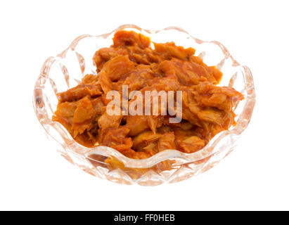 Side view of a small glass bowl of spicy flavored pink salmon isolated on a white background. Stock Photo