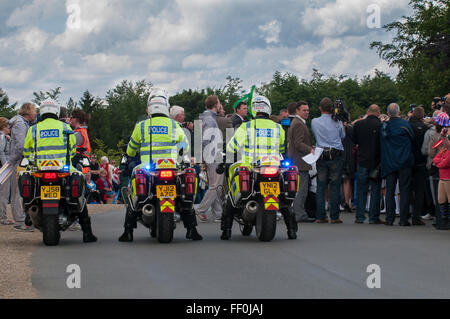 Rear view of 3 police motorcycle traffic control officers, stationary on their bikes, watching the crowd at cycling event Yorkshire, England, GB, UK. Stock Photo