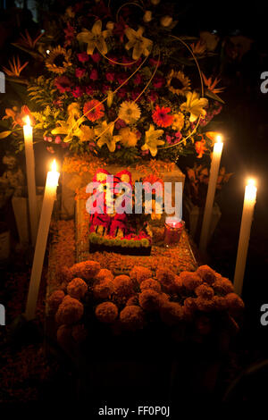 A jaguar toy made with flower petals and yellow marigold flowers, known as cempasuchil, decorate a tomb at the cemetery Stock Photo