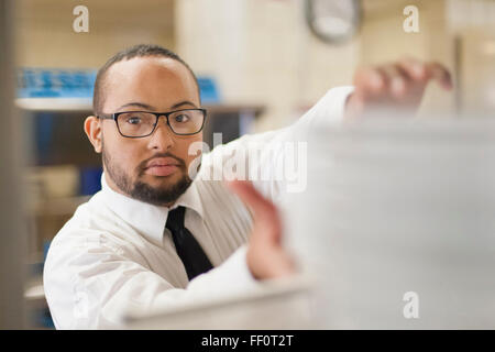 Mixed race server with down syndrome working in restaurant Stock Photo