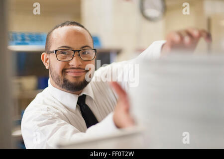 Mixed race server with down syndrome working in restaurant Stock Photo