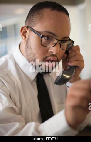 Mixed race man talking on telephone Stock Photo