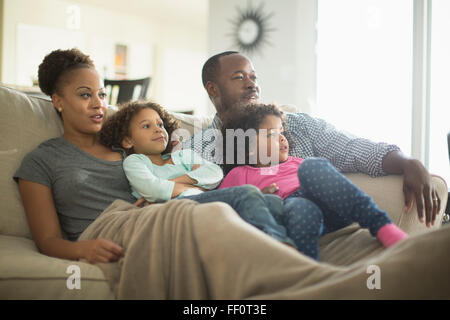 Family watching television on sofa Stock Photo