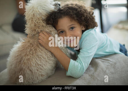 Mixed race girl hugging dog Stock Photo