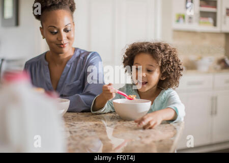 Mother and daughter eating at table Stock Photo