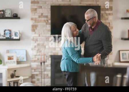 Older couple dancing in living room Stock Photo