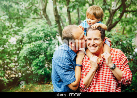 Gay fathers holding baby son outdoors Stock Photo