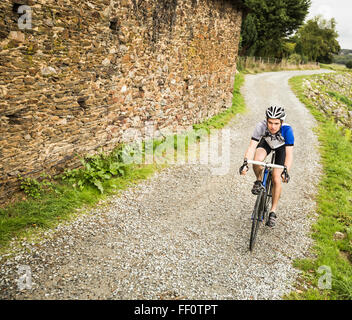 Caucasian man cycling on gravel path Stock Photo