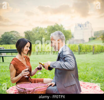 Caucasian couple enjoying wine at picnic Stock Photo