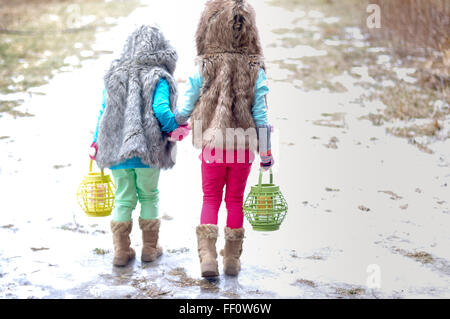 Caucasian girls holding hands in snow Stock Photo
