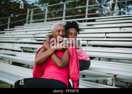 Grandmother and granddaughter sitting on bleachers Stock Photo