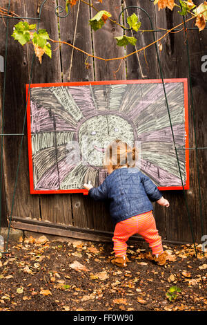 Caucasian baby girl drawing outdoors Stock Photo