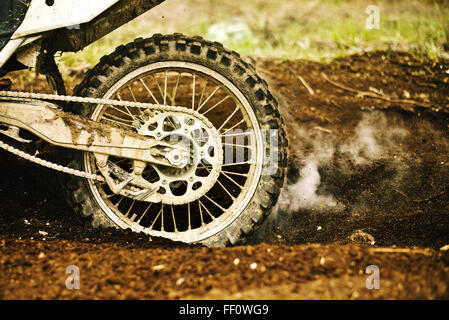 Dirt bike tire smoking in dirt Stock Photo